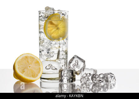 Bicchiere pieno di acqua fresca con limone e cubetti di ghiaccio su sfondo Foto Stock