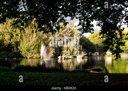 La casa di uccelli, St James Park, Londra con fontana e un effetto arcobaleno. bellissimo parco pubblico. condizioni atmosferiche variabili - sole e nuvole scure. Foto Stock