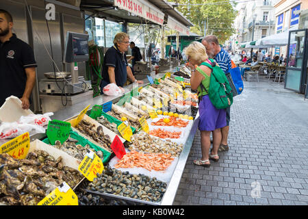 Una coppia più anziana che guarda un mercato di pesce e frutti di mare a Marsiglia, Francia Foto Stock