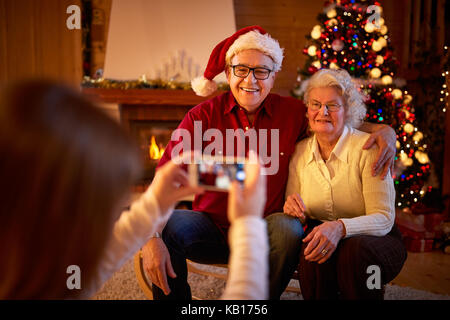 Ragazza con lo smartphone sta immagine nonni alla vigilia di Natale Foto Stock