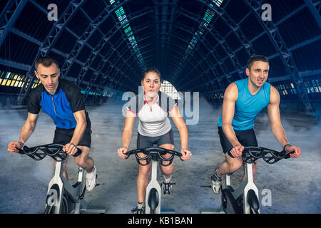 Un gruppo di tre persone esercitano sulla bici, classe di filatura, Foto Stock