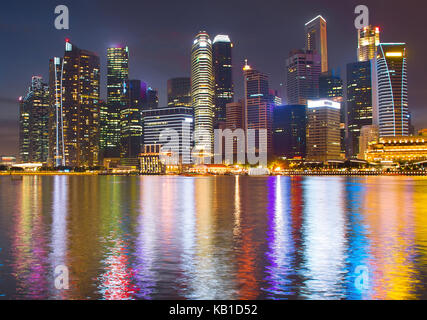 Vista di Singapore downtown core riflessa in un fiume di notte Foto Stock