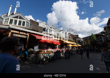 Fiori d'estate e ristoranti rendono la scena colorati in Whistler Village, Whistler, BC, Canada. Foto Stock