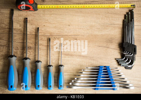 Set di diversi strumenti di costruzione su un sfondo di legno. Foto Stock