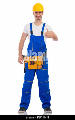 Sorridente giovane uomo in uniforme di costruzione che mostra pollice in alto Foto Stock