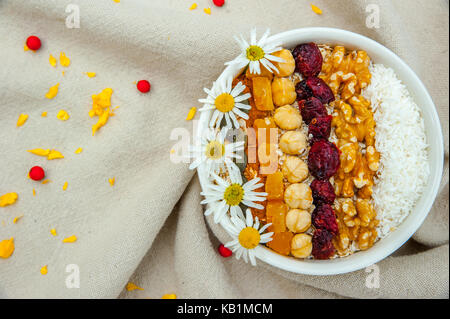 Vista superiore muesli con frutta a guscio, la frutta secca e le margherite Foto Stock