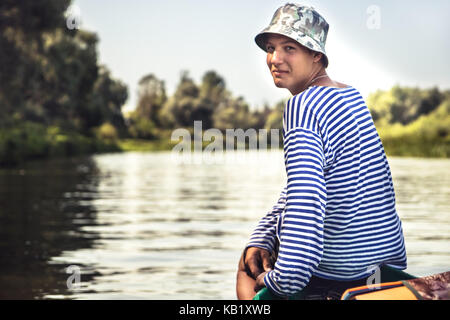 Bello semplice ragazzo adolescente in viaggio in battello sul fiume durante la campagna Summer Camp vacanze Foto Stock