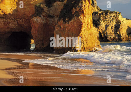 Il Portogallo, Algarve, le onde e le cozze falesie calcaree sulla roccia spiaggia prainha vicino a alvor, Foto Stock