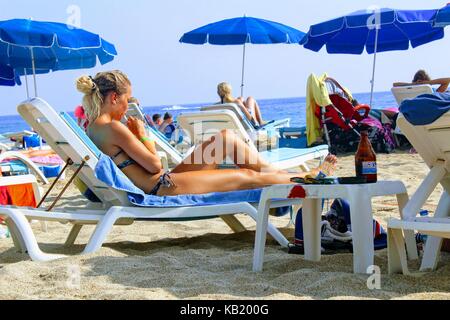 Luglio, 2017 - persone appoggiano sulle sedie a sdraio all'ombra di ombrelloni sulla spiaggia di cleopatra (Alanya, Turchia). Foto Stock