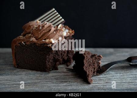Torta al cioccolato fondente con forcella su sfondo scuro Foto Stock