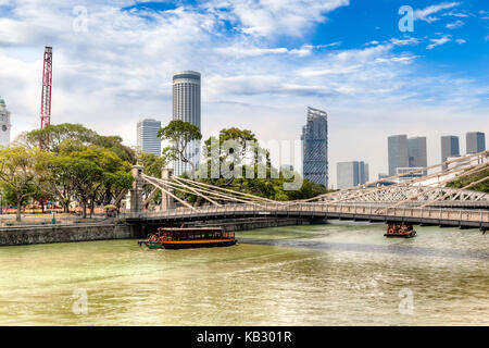 Tela bumboats il fiume Singapore sul boat quay sotto cavenagh bridge, l'unico ponte di sospensione e il ponte più antico di Singapore. Inaugurato nel 1870, Foto Stock