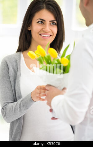 Bella ragazza riceve un bouquet dal suo fidanzato Foto Stock