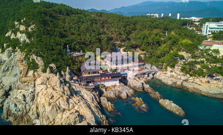 Angolo di Alta Vista Haedong Yonggungsa tempio di Busan, Corea del Sud scenario consistono di tempio si trova sulla scogliera vicino a bordo mare, montagna e cielo blu Foto Stock