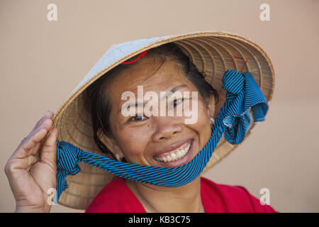 Il Vietnam, mui ne mui ne beach, donna con cappello tradizionale, sorridere Visualizza fotocamera, ritratto, Foto Stock