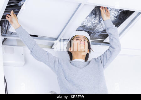 Elettricista femmina l'installazione di luci a soffitto Foto Stock