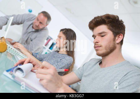 Agli studenti di prendere appunti in classe Foto Stock