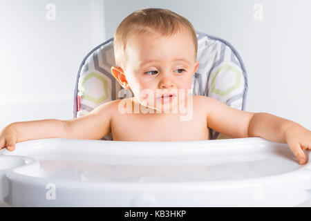 Bambino in sedia alta. kid in attesa per il preferito pappe per bambini Foto Stock