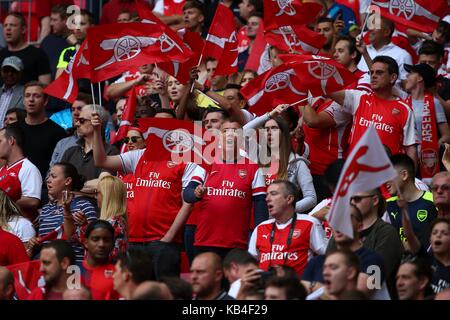 Arsenal Football Club sostenitori cantando e sventolando bandiere. Foto Stock