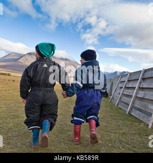 I bambini si tengono per mano nella campagna in un raduno di cavalli in Islanda. Annuale cavallo Round Up-Laufskalarett, Skagafjordur, Islanda. Foto Stock