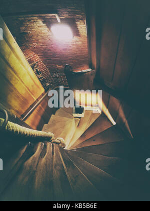 Scale di legno e di una luce in un vecchio edificio Foto Stock