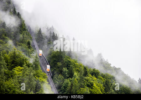 Due carri incrocio su una due-ferrovia funicolare nelle montagne di Hallstatt, Austria, su un nebbioso giorno Foto Stock