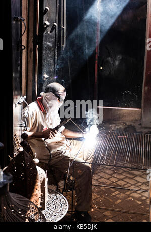 Lavoratore in Fabbri souk di metallo di saldatura, Marrakech, Marocco, Africa settentrionale, Africa Foto Stock