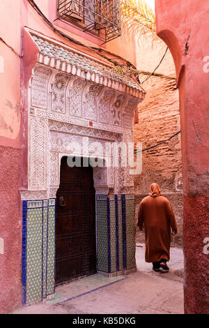 Local uomo vestito in djellaba tradizionale a piedi attraverso street nella Kasbah, Marrakech, Marocco, Africa settentrionale, Africa Foto Stock