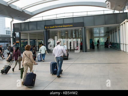 Passeggeri a piedi attraverso il terminal sud entrata a Gatwick Foto Stock