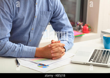 L'uomo studiando un report di analisi in un ufficio sfondo Foto Stock
