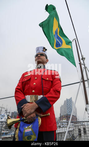 Amburgo, Germania. 28 Sep, 2017. Un membro di equipaggio del brasiliano di formazione della nave 'Navio Escola Brasil' sorge sul ponte della nave nel porto di Amburgo, Germania, 28 settembre 2017. Il brasiliano della nave di formazione ha attraccato nel porto di Amburgo per la ventiduesima volta. Credito: Jessica Mintelowsky/dpa/Alamy Live News Foto Stock