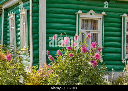 Casa di legno di campagna con fiori in giardino di assegnazione. Regione di Kaluga, Russia centrale. Foto Stock