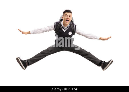 Overjoyed teenage studente in un uniforme jumping isolati su sfondo bianco Foto Stock