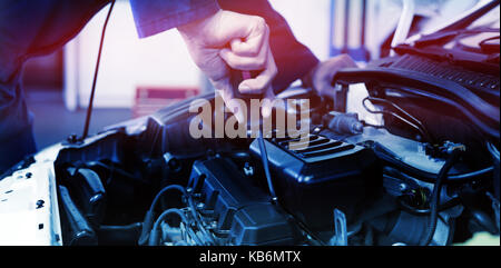 Meccanico con un cacciavite sul motore presso il garage di riparazione Foto Stock