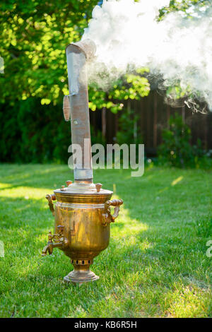 Tradizionale russo samovar riscaldamento e acqua bollente in un giardino estivo Foto Stock