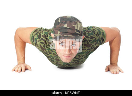 Giovane soldato dell'esercito facendo spingere in alto isolato su sfondo bianco.Vista frontale Foto Stock