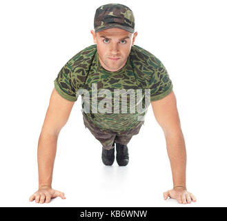 Giovane soldato dell'esercito facendo spingere in alto isolato su sfondo bianco.Vista frontale Foto Stock