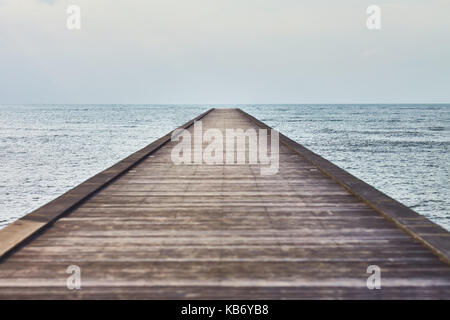 Vista in prospettiva di un molo di legno in un mare tropicale Foto Stock