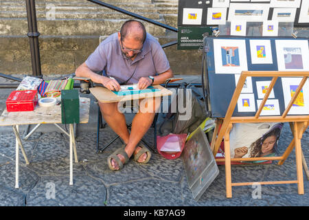 Artista in Piazza del Duomo, Firenze, Toscana, Italia che crea immagini da vendere ai turisti. Foto Stock