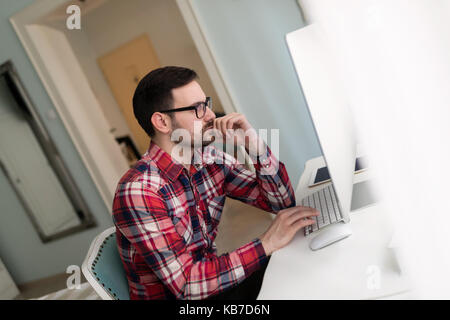 Bel giovane designer che lavorano sul progetto sul computer Foto Stock