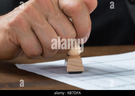 Immagine ritagliata di imprenditore documento di stampaggio alla scrivania Foto Stock