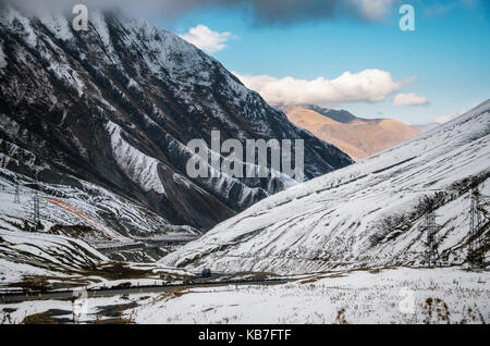 Georgian strada militare. la panoramica strada di avvolgimento tra le montagne innevate in Georgia. principale crinale caucasico e croce pass gudauri d'inverno. Foto Stock