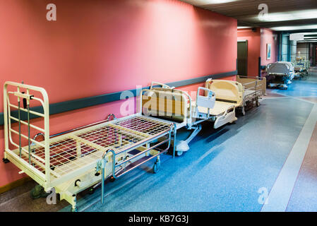 Paziente letti essendo memorizzata nel corridoio di un ospedale. Foto Stock