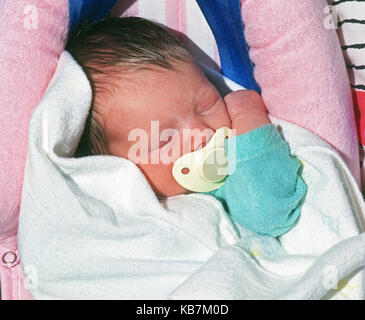 A due settimane di età ragazza bambino succhiare un succhietto come dorme Foto Stock