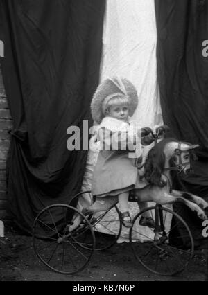 AJAXNETPHOTO. 1890 - 1914 (circa). Posizione sconosciuta. - Ben vestito bambino TODDLER indossando cappotto e cofano SAT a cavallo di un cavallo in stile vittoriano di triciclo in posa per la fotocamera. Il trike ha GOMME PIENE. Fotografo:sconosciuto © IMMAGINE DIGITALE COPYRIGHT VINTAGE AJAX Picture Library Fonte: AJAX FOTO VINTAGE COLLEZIONE REF:AVL 172109 1674 Foto Stock