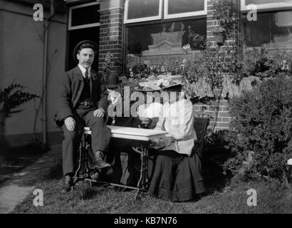 AJAXNETPHOTO. 1903. FINCHAM, Inghilterra. - Vini e Distillati - due ben vestito uomini con le donne rappresentano per la telecamera nel giardino di una casa pubblica. fotografo:sconosciuto © IMMAGINE DIGITALE COPYRIGHT VINTAGE AJAX Picture Library Fonte: AJAX FOTO VINTAGE COLLEZIONE REF:AVL 1173 Foto Stock