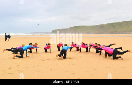 Istruttori di Surf dando lezioni di surf per i partecipanti sulla spiaggia, a Watergate Bay, Newquay Cornwall, England, Regno Unito Foto Stock