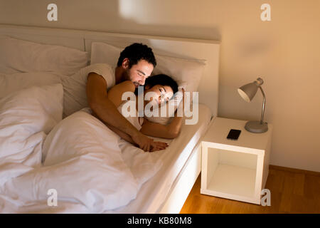 Amare giovane che dorme sul letto di casa Foto Stock