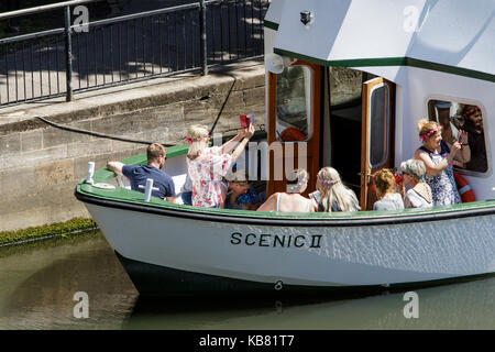 I turisti sono raffigurato seduto in una gita sul fiume in barca di crociera che si prepara per la partenza e il viaggio lungo il fiume Avon a bath somerset England Regno Unito Foto Stock