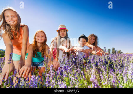 Felici i bambini e le bambine divertirsi nel campo di lavanda Foto Stock