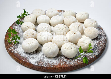 Khinkali sul piatto di legno con farina. pelmeni. Foto Stock